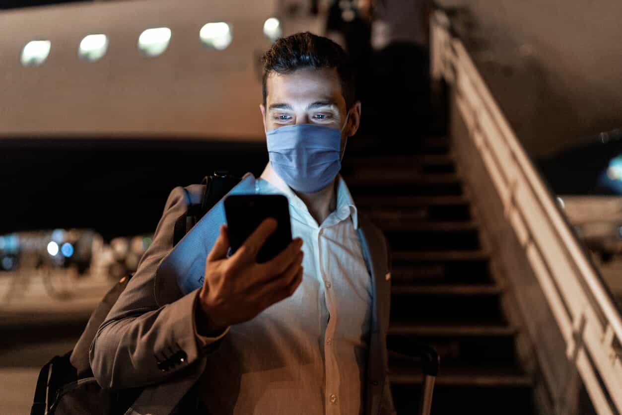 Businessman looking at his phone on a plane